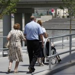 A disabled woman being wheeled down a ramp